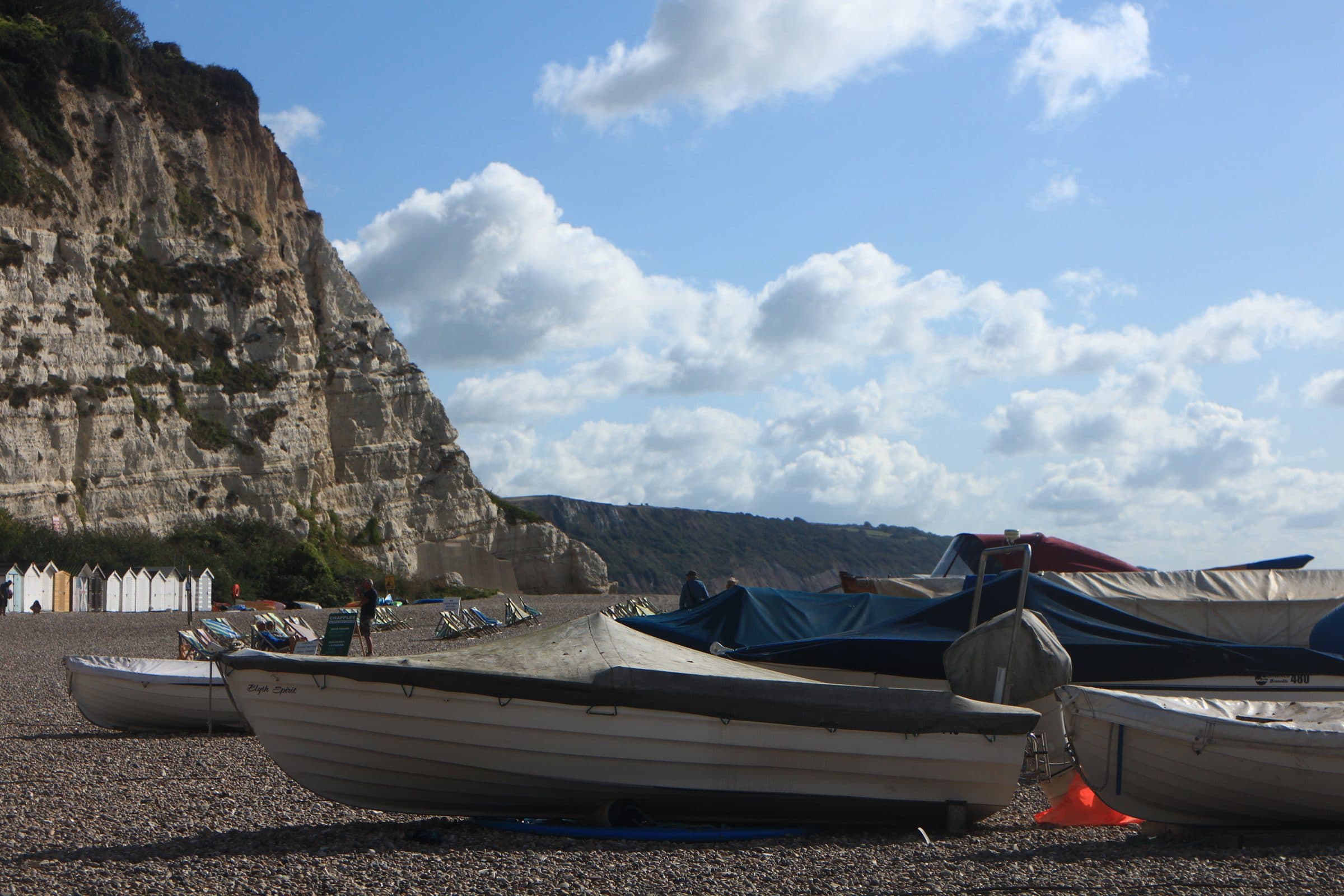 Fishing boats pulled up on the shingle at Beer, below the white chalk cliffs of the Jurassic Coast.