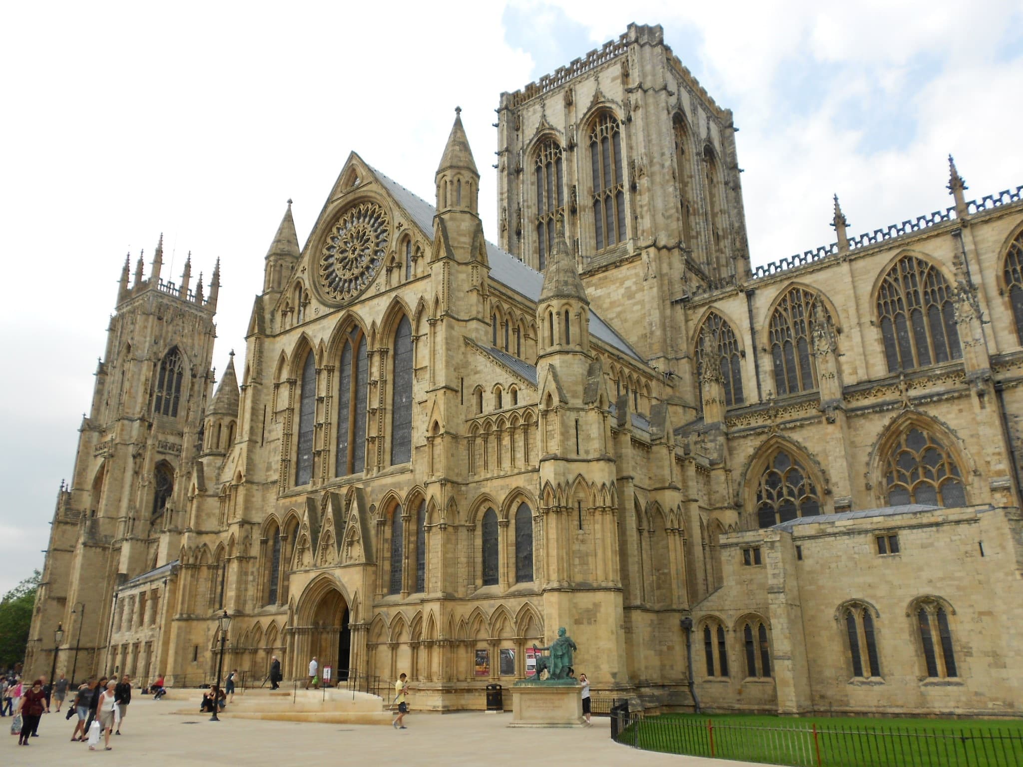 The west front of York Minster, its rose window and carved stonework rising above the street.